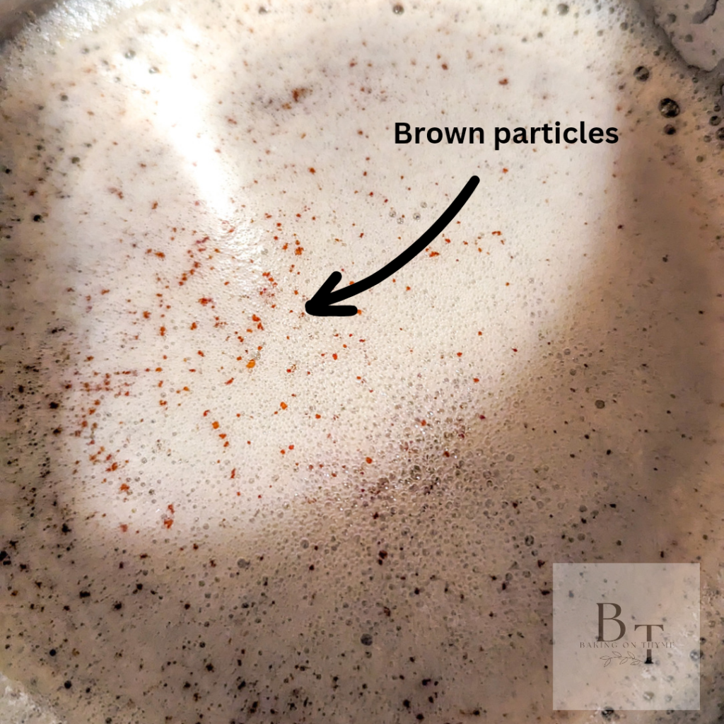 brown butter, with arrow showing butter particles in coking pot