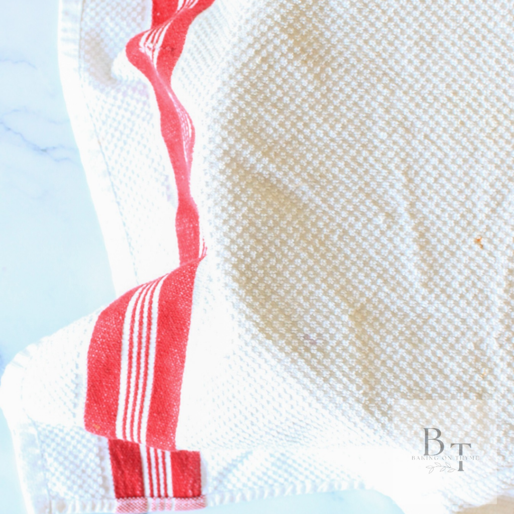 kitchen towel covering dough for hamburger buns