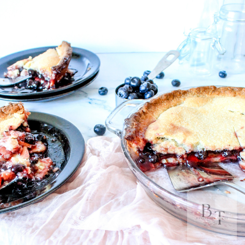 blueberry pie with two black plates that have pie on it